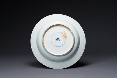 A Chinese blue and white dish with landscape and floral panels, Kangxi
