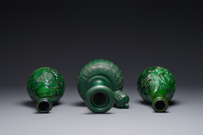 Two Chinese monochrome green-glazed stoneware 'dragon' vases and a kendi, Fujian kiln, late Ming