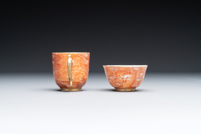 Two rare Chinese iron-red-decorated 'European scene' cups and a saucer, Qianlong