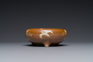 A rare Chinese Swatow slip-decorated brown-glazed tripod censer with cranes, Ming