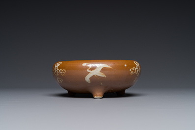 A rare Chinese Swatow slip-decorated brown-glazed tripod censer with cranes, Ming