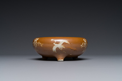 A rare Chinese Swatow slip-decorated brown-glazed tripod censer with cranes, Ming