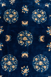Een groot Chinees donkerblauw tapijt met bloemen en vlinders, 19/20e eeuw