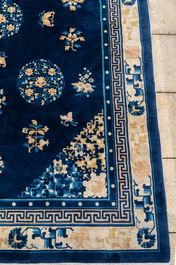 Een groot Chinees donkerblauw tapijt met bloemen en vlinders, 19/20e eeuw
