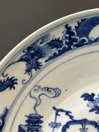 Een Chinese blauw-witte theepot met landschapsdecor en een schotel met kostbaarheden, 19e eeuw