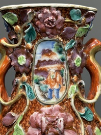 Een paar Chinese Canton famille rose vazen met mandarijns decor en bloemen in reli&euml;f, Qianlong