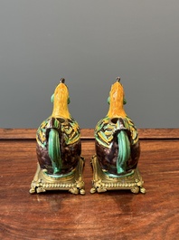 A pair of Chinese sancai-glazed chicken ewers mounted as candleholders with gilt bronze, Kangxi
