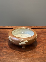 A rare Chinese Swatow slip-decorated brown-glazed tripod censer with cranes, Ming