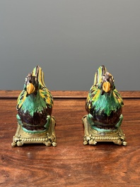 A pair of Chinese sancai-glazed chicken ewers mounted as candleholders with gilt bronze, Kangxi
