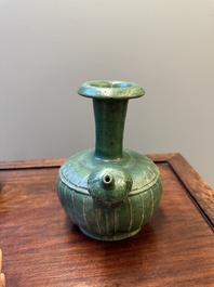 Two Chinese monochrome green-glazed stoneware 'dragon' vases and a kendi, Fujian kiln, late Ming