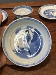 Four Chinese blue and white saucers and an 'erotic' cup, Kangxi