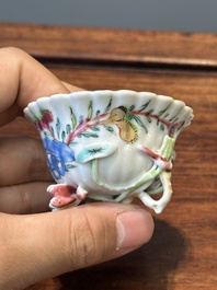 A Chinese famille rose relief-decorated cup and saucer, Yongzheng