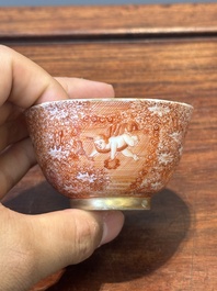 Two rare Chinese iron-red-decorated 'European scene' cups and a saucer, Qianlong