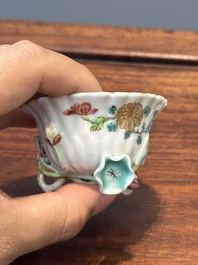 A Chinese famille rose relief-decorated cup and saucer, Yongzheng