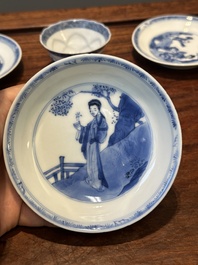 Four Chinese blue and white saucers and an 'erotic' cup, Kangxi