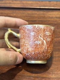 Two rare Chinese iron-red-decorated 'European scene' cups and a saucer, Qianlong