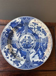 A Chinese blue and white dish with landscape and floral panels, Kangxi
