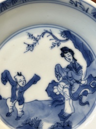 Four Chinese blue and white saucers and an 'erotic' cup, Kangxi