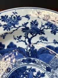 A Chinese blue and white dish with landscape and floral panels, Kangxi