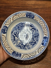 A Chinese blue and white reticulated double-walled cup and saucer, Kangxi