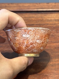 Two rare Chinese iron-red-decorated 'European scene' cups and a saucer, Qianlong
