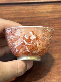 Two rare Chinese iron-red-decorated 'European scene' cups and a saucer, Qianlong