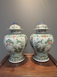 A pair of Chinese famille verte 'bird and flower' vases and covers, Kangxi mark, 19th C.