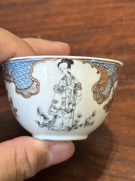 Een Chinese famille rose en grisaille kop en schotel met Xiwangmu die een perzik aangeboden krijgt, Yongzheng