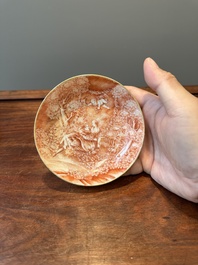 Two rare Chinese iron-red-decorated 'European scene' cups and a saucer, Qianlong
