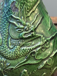 Two Chinese monochrome green-glazed stoneware 'dragon' vases and a kendi, Fujian kiln, late Ming