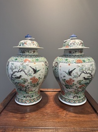 A pair of Chinese famille verte 'bird and flower' vases and covers, Kangxi mark, 19th C.