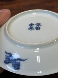 Four Chinese blue and white saucers and an 'erotic' cup, Kangxi