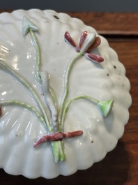 A Chinese famille rose relief-decorated cup and saucer, Yongzheng