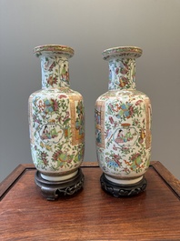 Een paar Chinese Canton famille rose vazen met houten sokkel, 19e eeuw