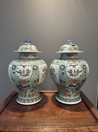 A pair of Chinese famille verte 'bird and flower' vases and covers, Kangxi mark, 19th C.