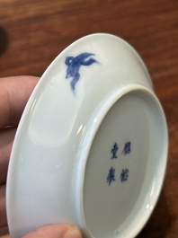 Four Chinese blue and white saucers and an 'erotic' cup, Kangxi