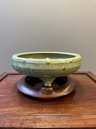 A Chinese Longquan celadon tripod censer on wooden stand, Yuan/Ming
