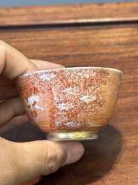 Two rare Chinese iron-red-decorated 'European scene' cups and a saucer, Qianlong