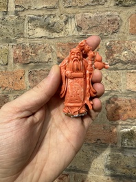 A set of seven Chinese red coral figures on wooden stand, 19/20th C.