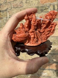 A Chinese red coral 'Eight Immortals' group on wooden stand, 19/20th C.