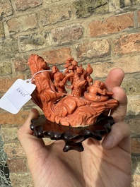 A Chinese red coral 'Eight Immortals' group on wooden stand, 19/20th C.