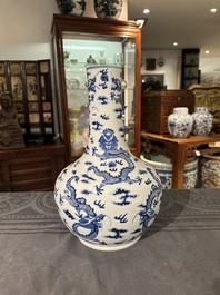 A Chinese blue and white bottle vase with dragons among flames and clouds, 19th C.