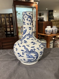 A Chinese blue and white bottle vase with dragons among flames and clouds, 19th C.