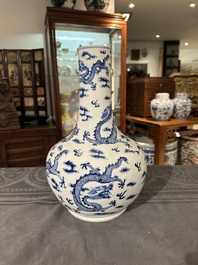 A Chinese blue and white bottle vase with dragons among flames and clouds, 19th C.