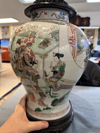 Two Chinese famille verte covered vases on wooden stands, 19th C.