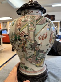 Two Chinese famille verte covered vases on wooden stands, 19th C.