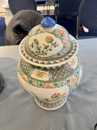 Two Chinese famille verte covered vases on wooden stands, 19th C.