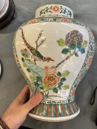 Two Chinese famille verte covered vases on wooden stands, 19th C.
