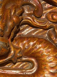 A pair of Chinese gilt-lacquered wooden guardians and a round 'dragon' plaque, 19th C.