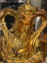 A pair of Chinese gilt-lacquered wooden guardians and a round 'dragon' plaque, 19th C.